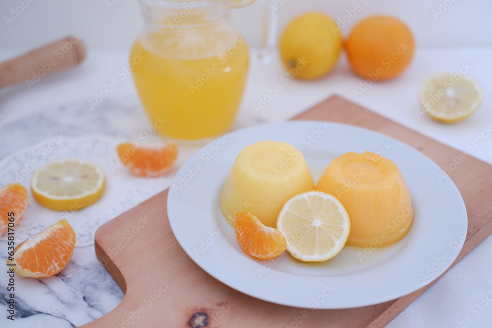 Orange jelly with fresh lemon and orange juice on a white background.