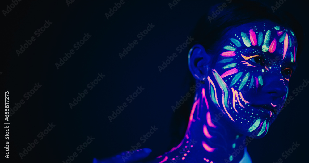 Obraz premium Innovative Beauty Advertising Shoot: Talented Model Showcases Her Unique Style, Neon-Painted Body and Face Contrasting Beautifully with Dark Backdrop, Creating a Visually Stunning Close Up Portrait