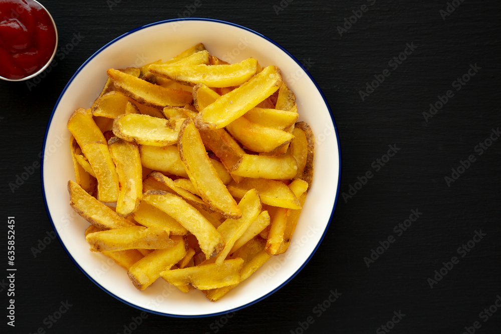 Homemade French Fries on a Plate on a black background, top view. Flat lay, overhead, from above. Copy space. Homemade French Fries on a Plate on a black background, top view. Flat lay, overhead, from above. Copy space.