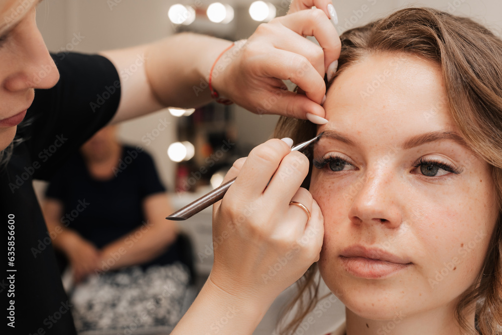 Shooting in a beauty salon. makeup artist applies makeup to the bride Shooting in a beauty salon. makeup artist applies makeup to the bride