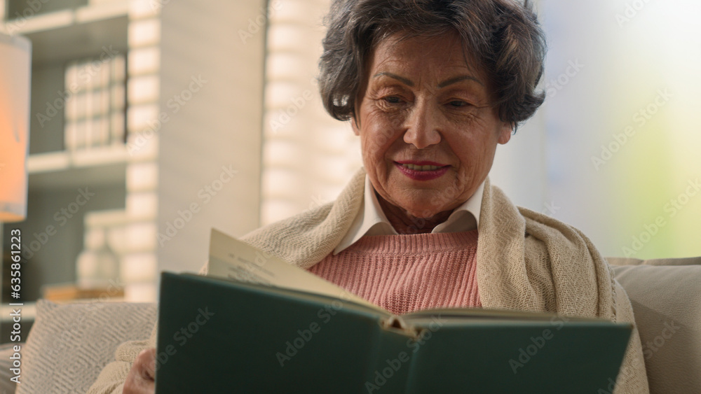 Happy inspired Caucasian old woman reading book smiling nostalgic