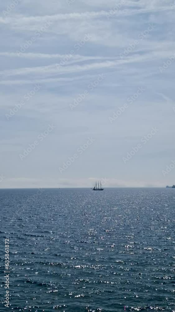Raid of ships in the waters of Barcelona. Waves on the blue sea and white clouds on the blue sky Raid of ships in the waters of Barcelona. Waves on the blue sea and white clouds on the blue sky