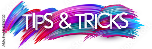 Tips and tricks paper word sign with colorful spectrum paint brush strokes over white.