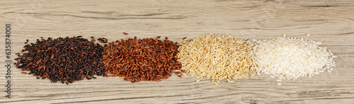 Four different types of Rice, Black, Red, Brown, and White on a wooden background with copy space