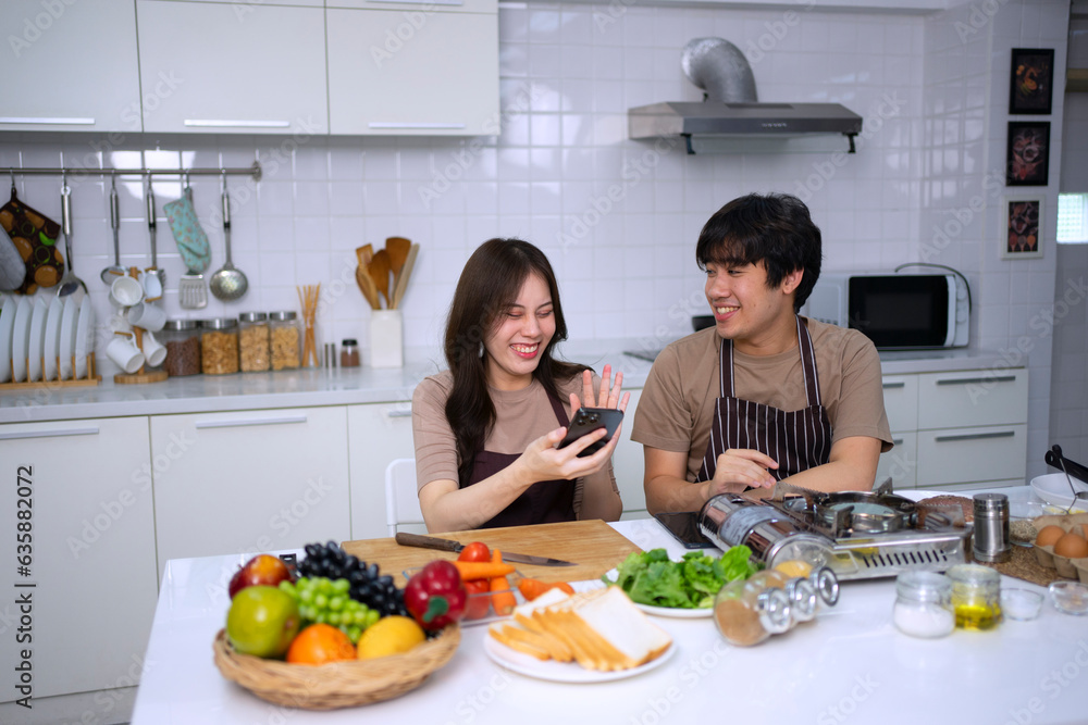 Young couple is livestreaming in kitchen.