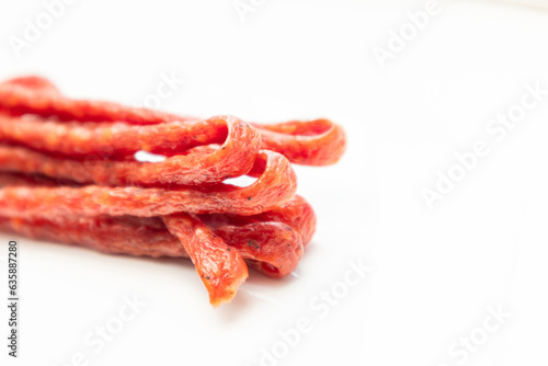 Pork or beef sausage, dry sausages, meat stick smoked close-up. Polish thin, long, dry sausage on a white background