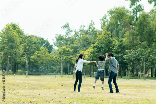 Happy Asian family spending time together outside in green nature and park, vacation of parents concept. © khwanchai