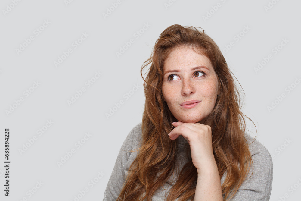 Cute redhead woman looking up on white background, studio portrait Cute redhead woman looking up on white background, studio portrait