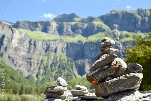 Stack of balancing rocks symbolising peace and mindfulness over a lush mountain landscape © tommoh29