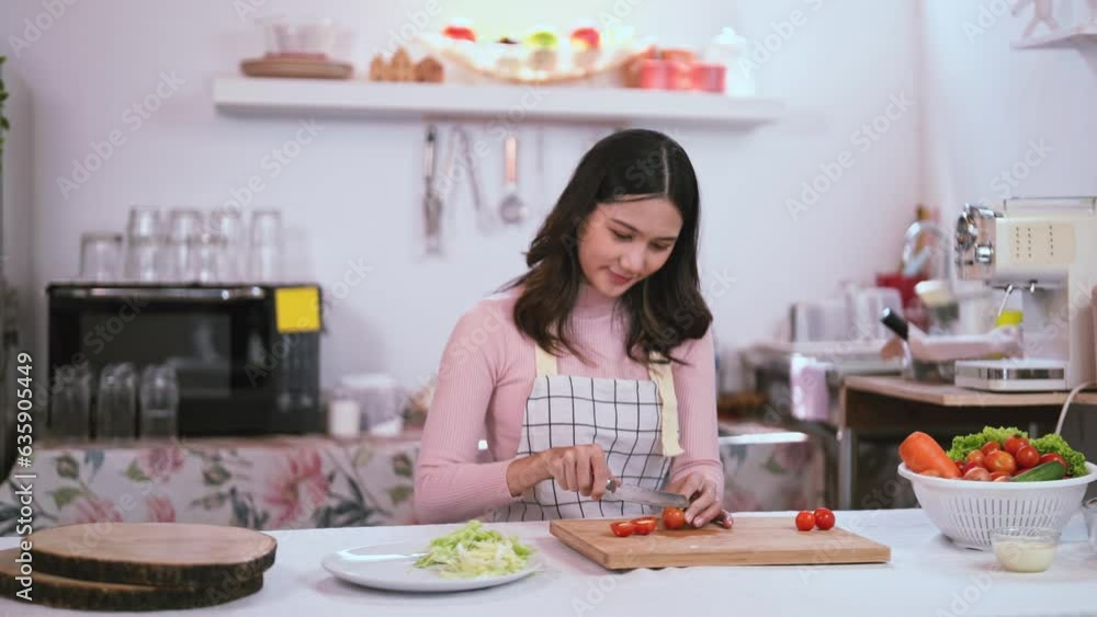 young Asian preparing by cutting vegetable to make salad in kitchen, enjoy cooking foods. young Asian preparing by cutting vegetable to make salad in kitchen, enjoy cooking foods.