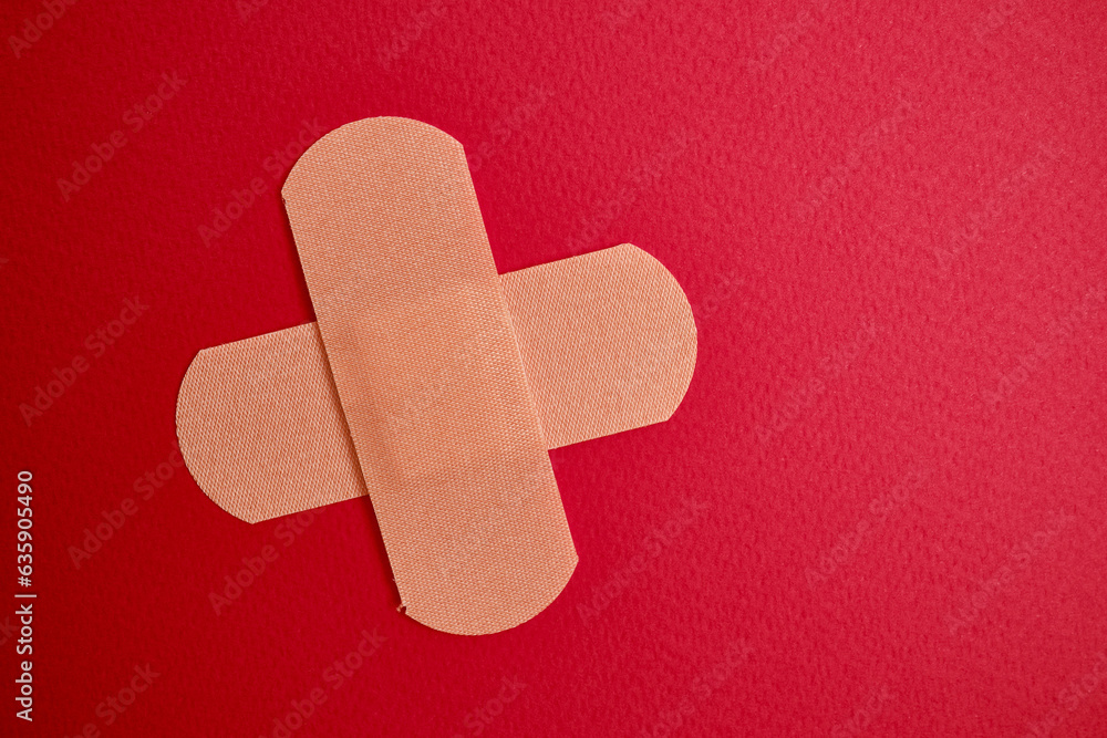 Medical plaster on a red background. Blood donation, space for text. Health and medicine concept Medical plaster on a red background. Blood donation, space for text. Health and medicine concept