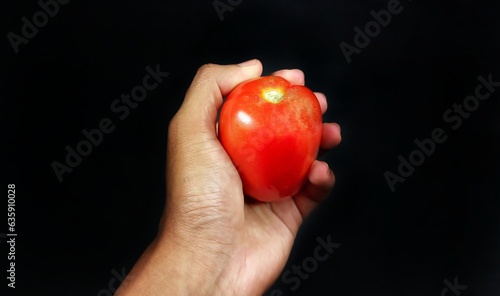 a tomato held by a man