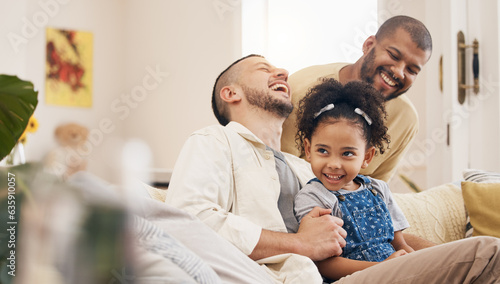 Gay family, laughing and a child on a home sofa with love, care and funny joke in lounge. Lgbtq men, adoption and parents with foster girl kid together on a couch for happiness, bonding and to relax