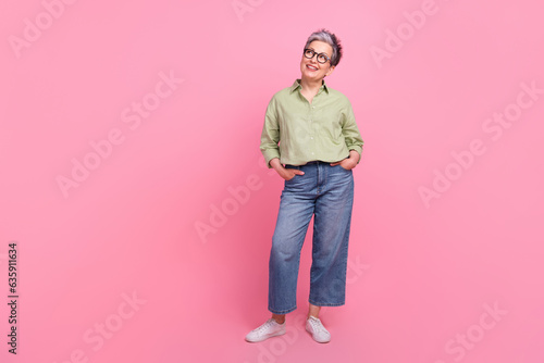 Full length body photo of optimistic dreaming businesswoman wear denim jeans khaki shirt look novelty isolated on pink color background
