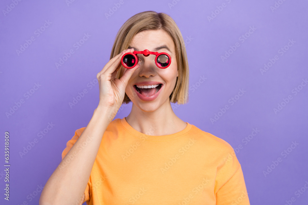 Photo of funny ecstatic girl with bob hairstyle dressed yellow t-shirt look in binoculars at big sale isolated on violet background Photo of funny ecstatic girl with bob hairstyle dressed yellow t-shirt look in binoculars at big sale isolated on violet background