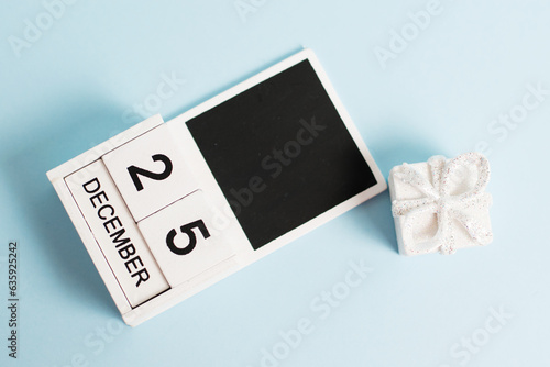 Christmas, wooden calendar with the date December 25 on a blue background with decor, flatlay. The concept of preparing for the celebration of Christmas and New Year and plans for the future