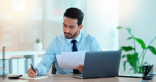 Lawyer and attorney working on corporate plans and compiling legal reports for a case at his desk. Business man and project manager reading and writing notes while working on a laptop in an office