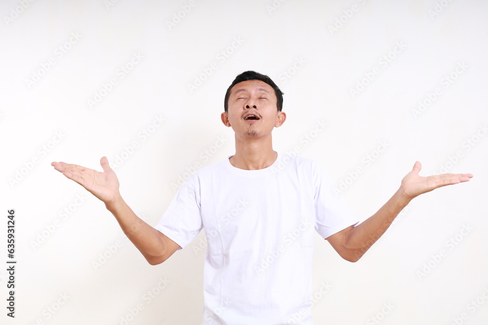 Wow expression of asian funny man receiving something from above with open hands. Isolated on white Wow expression of asian funny man receiving something from above with open hands. Isolated on white