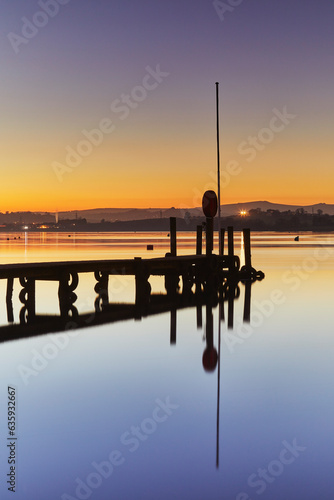 A very calm dusk scene, with a wooden jetty on the estuary of the River Teign, at Coombe Cellars, near Newton Abbot, south coast of Devon, England, United Kingdom photo
