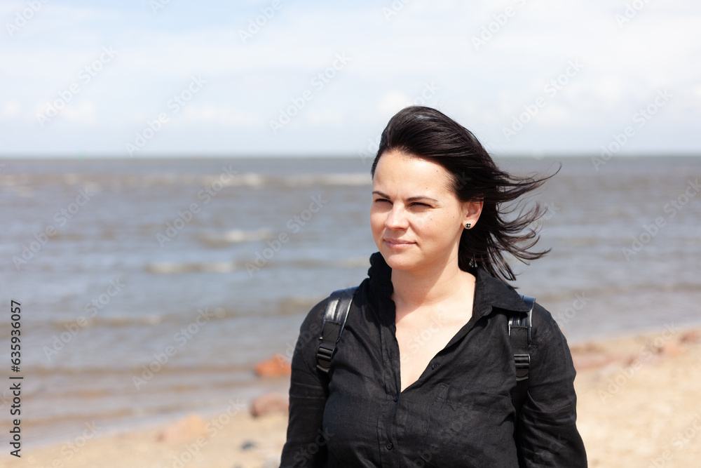Brunette girl in black leather jacket on the seashore Brunette girl in black leather jacket on the seashore