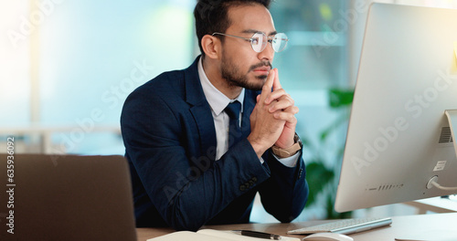 Business man analyzing a project strategy on a computer screen while working in an office. Serious and focused corporate professional thinking of solutions while considering ideas, choices and plans
