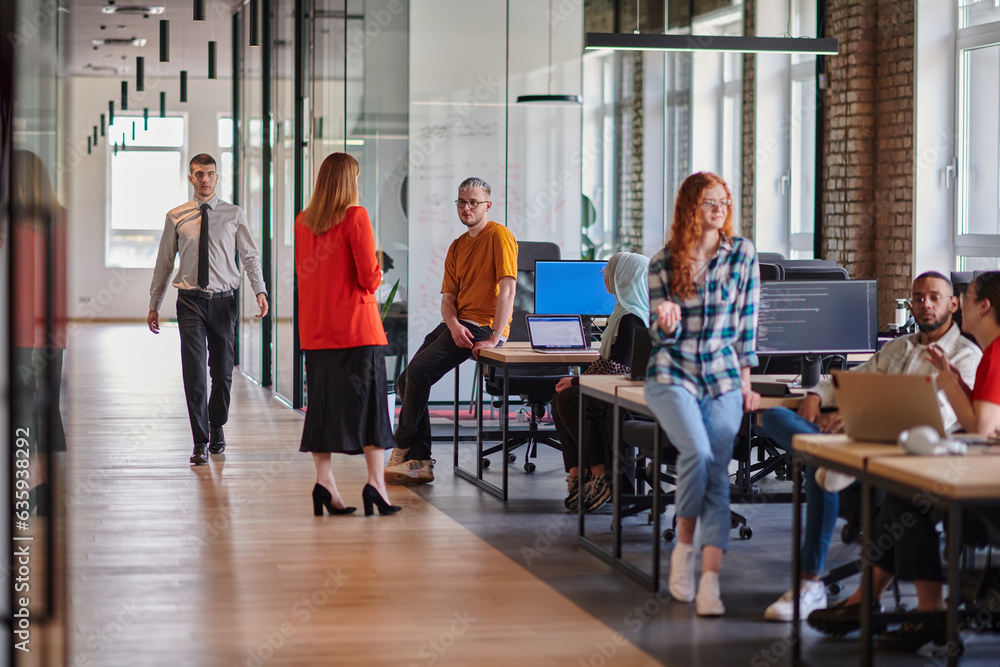 Obraz premium A diverse group of young business individuals congregates in a modern startup coworking center, embodying collaborative innovation and a dynamic atmosphere.