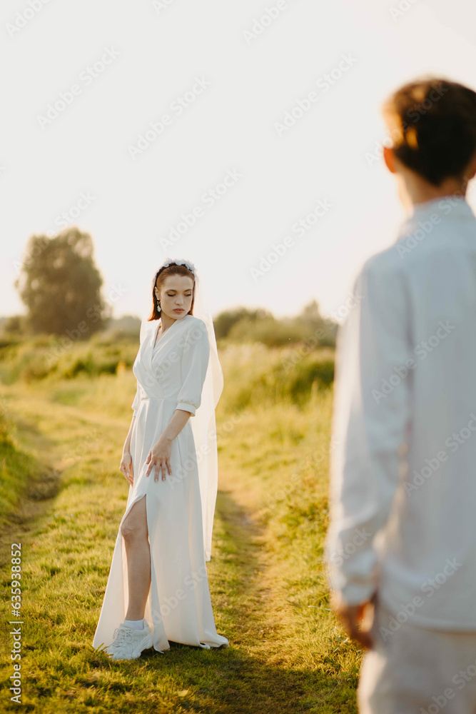 loving couple of newlyweds in a field in nature in summer. Romantic walk of lovers at sunset.