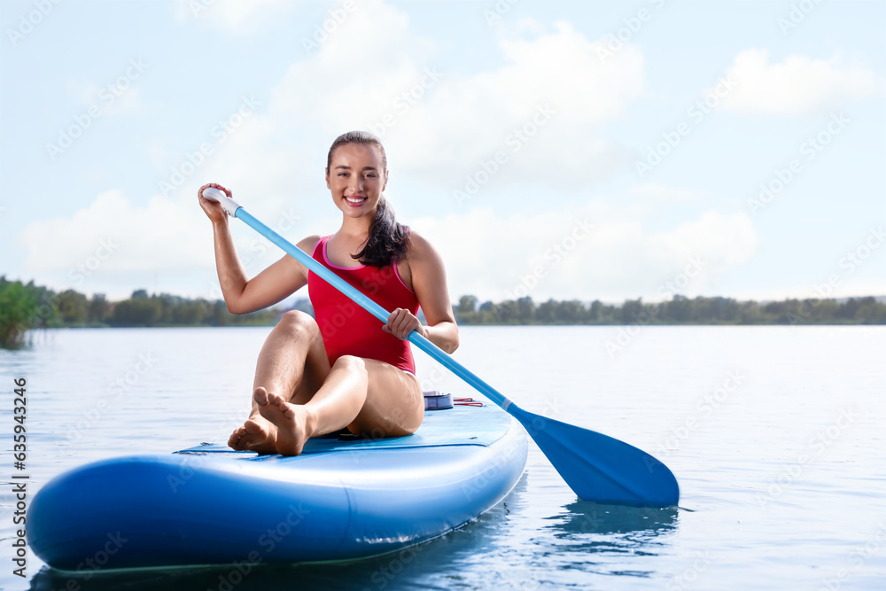 Woman paddle boarding on SUP board in sea, space for text