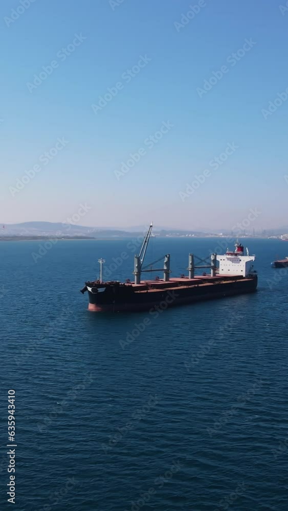 Bulk cargo carrier sea ship anchored in Aegean sea waiting entering port, Aerial vertical shot Bulk cargo carrier sea ship anchored in Aegean sea waiting entering port, Aerial vertical shot