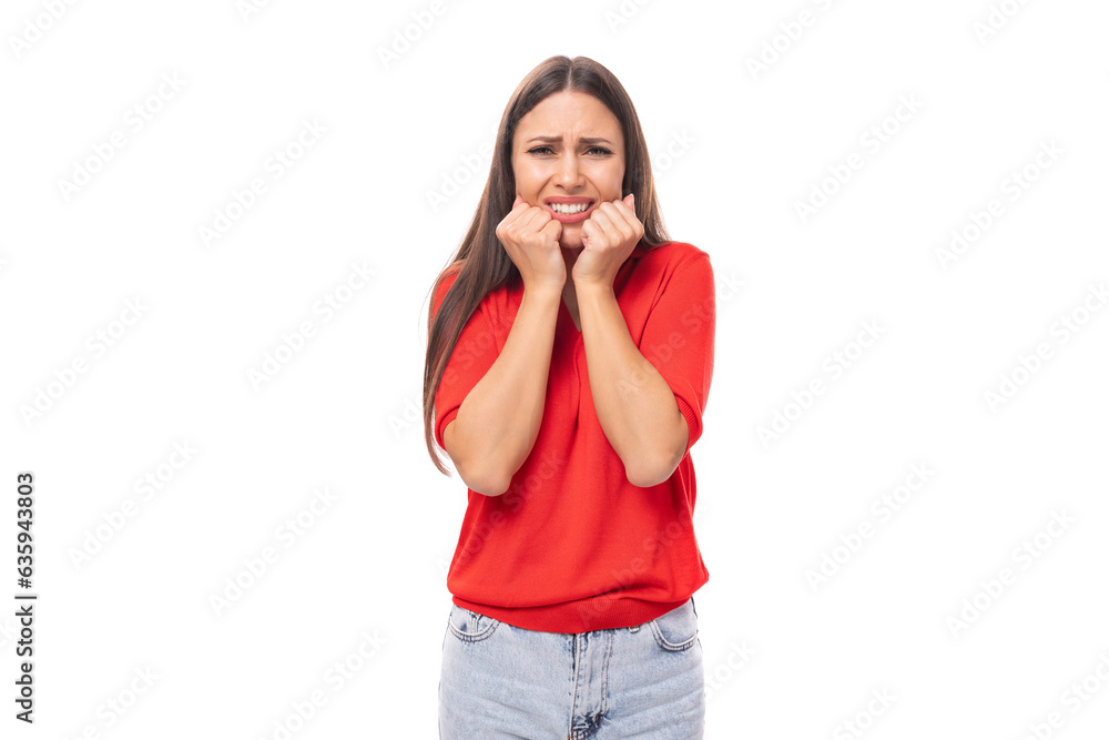 portrait of worried brunette woman with straight hair in red t-shirt and jeans isolated studio background with copy space portrait of worried brunette woman with straight hair in red t-shirt and jeans isolated studio background with copy space