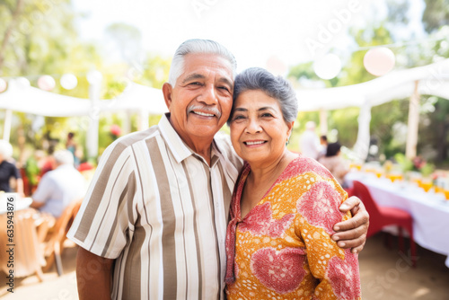 Portrait of a happy smiling Mexican senior couple at family gathering outdoors