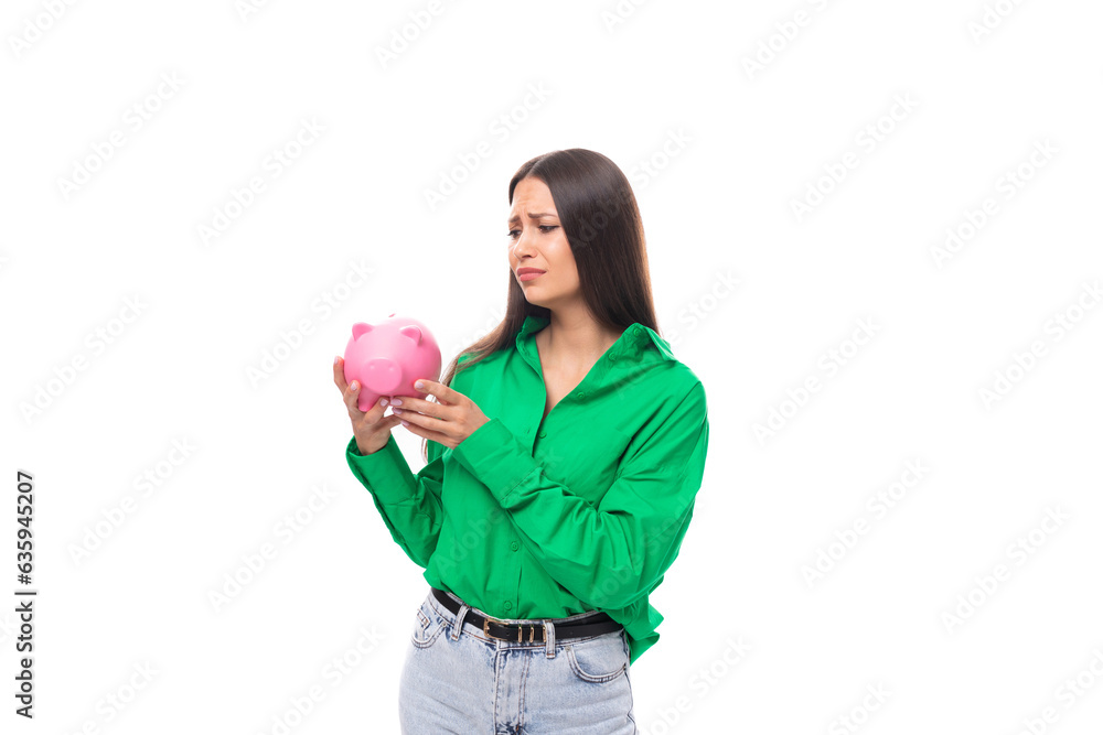 cute young brown-eyed brown-haired woman with makeup in a green blouse decides where to spend the savings of the piggy bank cute young brown-eyed brown-haired woman with makeup in a green blouse decides where to spend the savings of the piggy bank