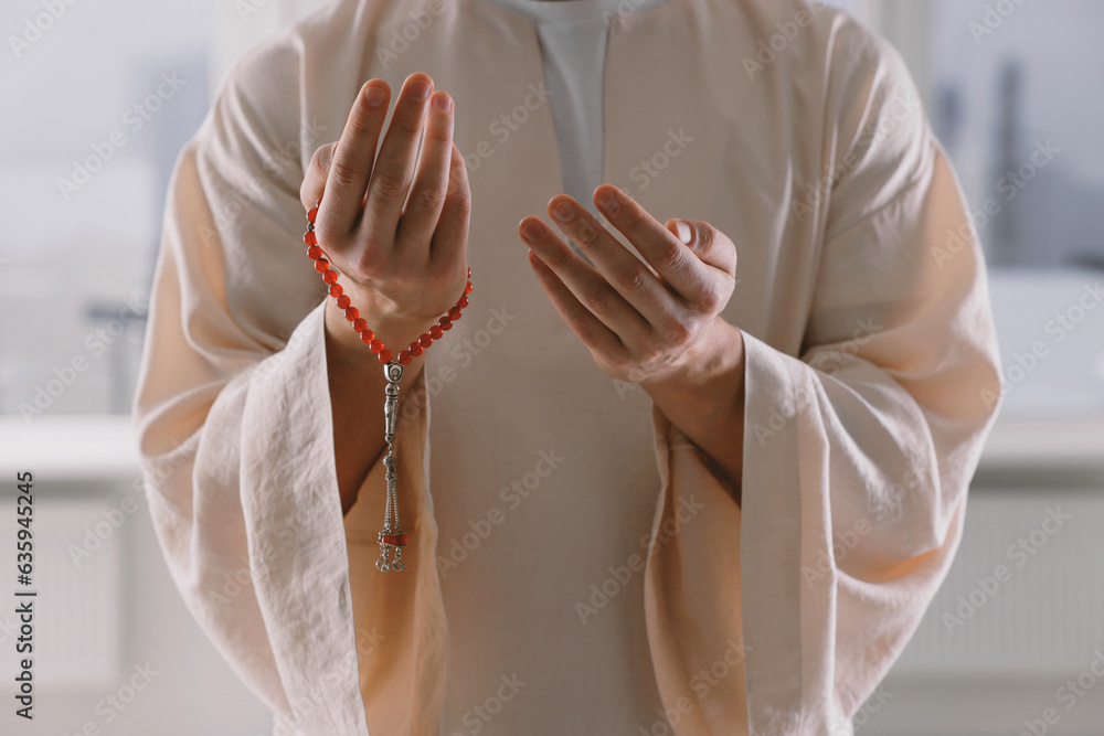 Obraz premium Muslim man with misbaha praying near window indoors, closeup