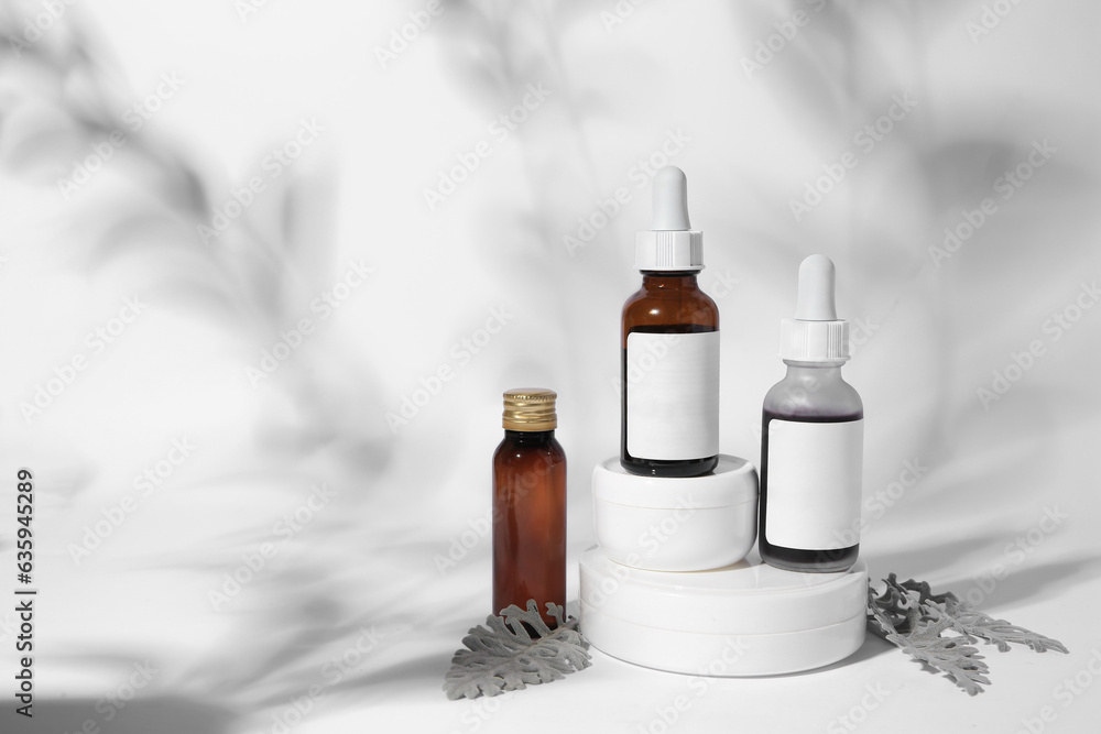 Fototapeta premium Cosmetic products and silver leaves on white background. Space for text