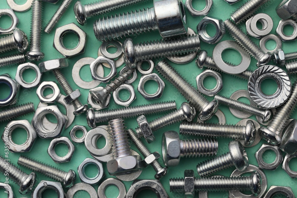 Different metal bolts and nuts on turquoise background, flat lay Different metal bolts and nuts on turquoise background, flat lay