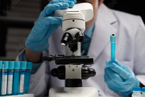 male medical scientist examining specimen using microscope in modern laboratory.