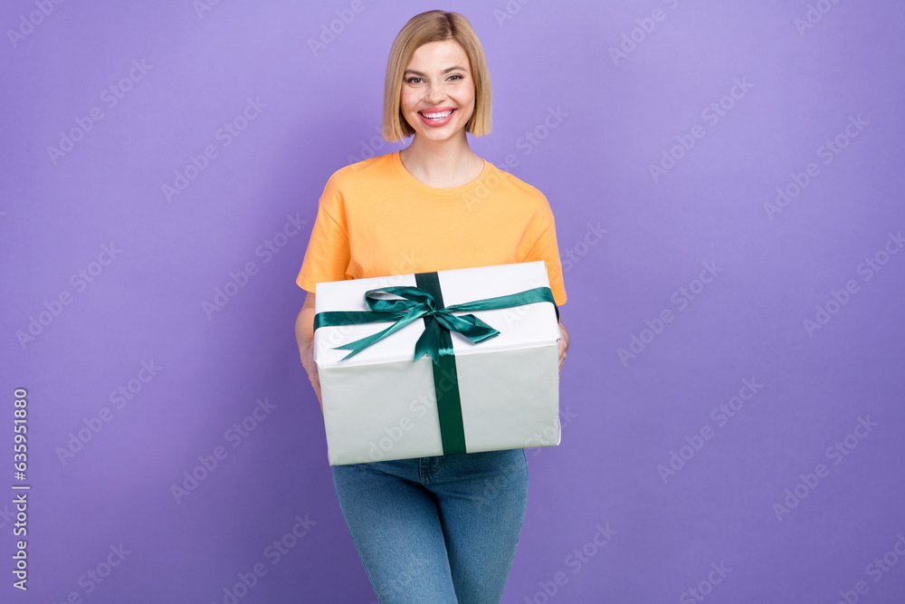 Photo of optimistic friendly woman with bob hairstyle wear yellow t-shirt hold present box on birthday isolated on purple color background Photo of optimistic friendly woman with bob hairstyle wear yellow t-shirt hold present box on birthday isolated on purple color background