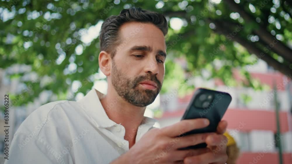 Hispanic businessman texting mobile phone message at city cafe terrace close up Hispanic businessman texting mobile phone message at city cafe terrace close up