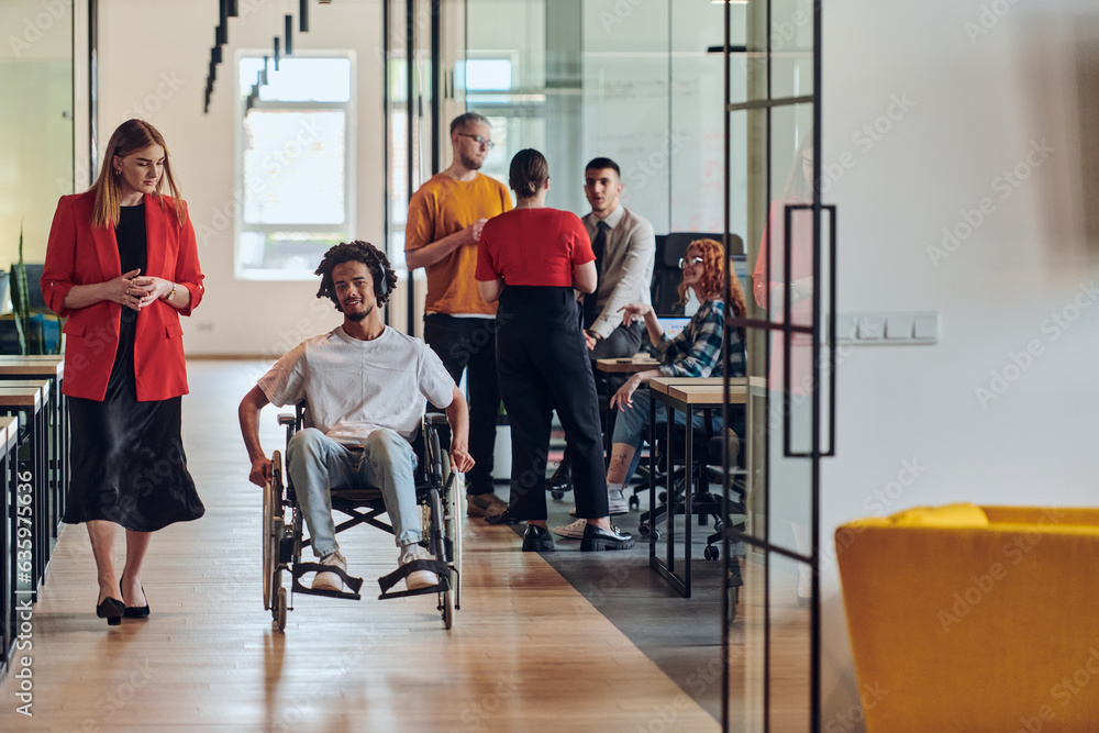A group of young business people in a modern glass-walled office captures the essence of diversity and collaboration, while two colleagues, including an African American businessman in a wheelchair A group of young business people in a modern glass-walled office captures the essence of diversity and collaboration, while two colleagues, including an African American businessman in a wheelchair