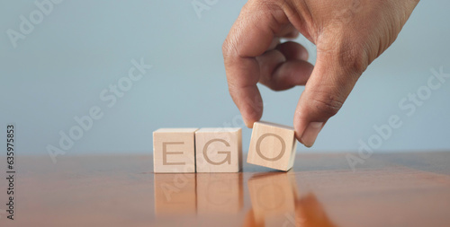 Quadro su tela wooden alphabet blocks reading - Ego - balanced in the palm of his hand in a conceptual image