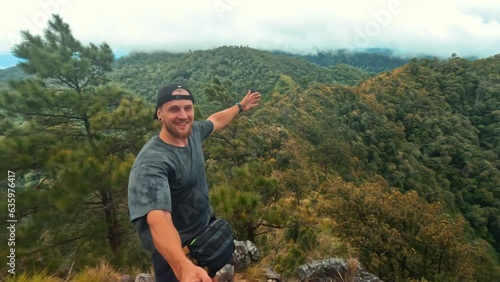 Young happy carefree hiker man recording selfie vlog video on action camera with amazing breathtaking mountain view, hiqh quality 4K slowmotion travel active lifestyle concept. Northern Thailand. photo