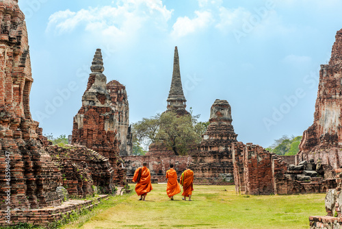 Monks walking beside a temple in Ayuttaya photo