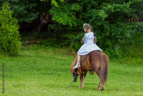 little girl riding a pony © zokov_111
