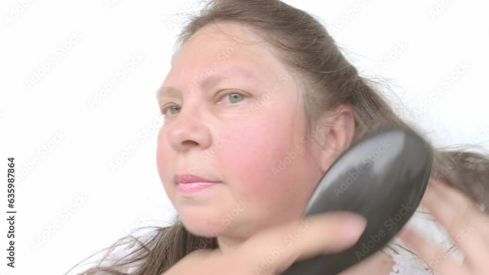 close up middle-aged female face, brown-haired woman 50-55 years old examines long brown with gray hair, age-related changes, self-appreciation, Hair care close up middle-aged female face, brown-haired woman 50-55 years old examines long brown with gray hair, age-related changes, self-appreciation, Hair care