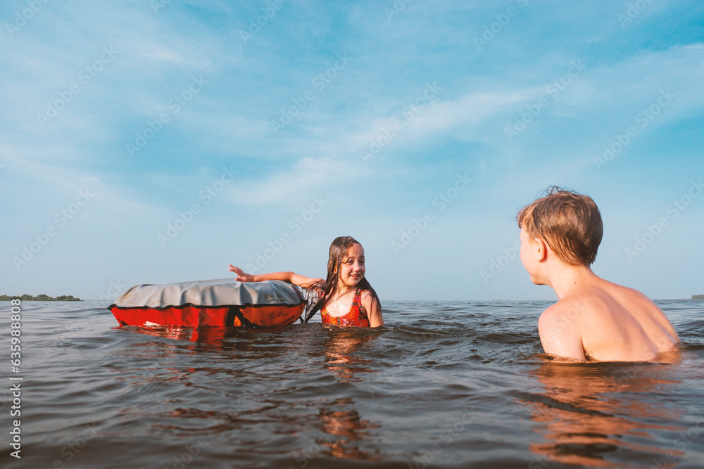 Obraz premium Children play in the water with an inflatable ring.