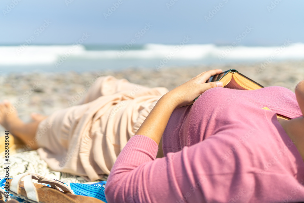 Woman taking a break from reading on the beach