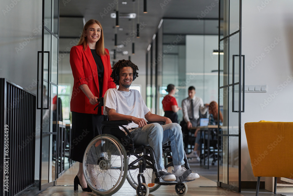 A group of young business people in a modern glass-walled office captures the essence of diversity and collaboration, while two colleagues, including an African American businessman in a wheelchair A group of young business people in a modern glass-walled office captures the essence of diversity and collaboration, while two colleagues, including an African American businessman in a wheelchair