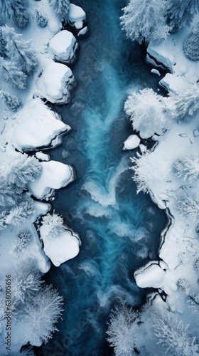 Top view of the river in the middle of a snowy forest. © Andrey