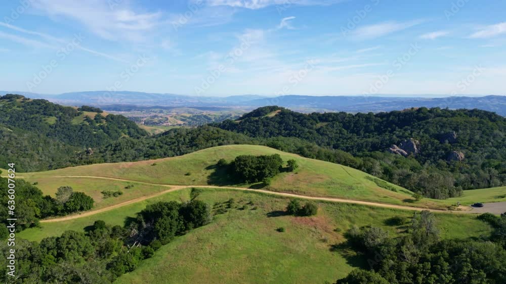 Landscape view of green hills with trees under blue sky Landscape view of green hills with trees under blue sky