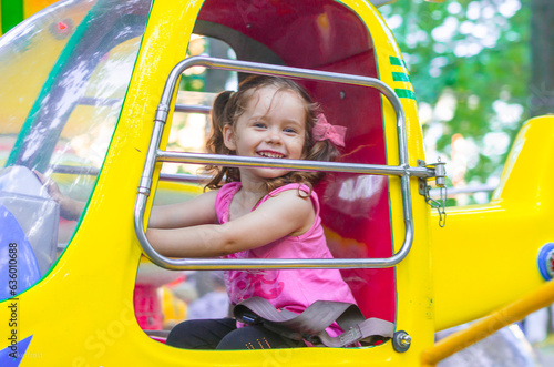 Happy child in the cockpit of a helicopter on a carousel in an amusement park